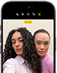 iPhone 18 Pro, สีดำ, ภายนอกด้านหน้า, แสดงให้เห็นสองคนกำลังโพสท่าให้กล้องเพื่อสาธิตกล้องหน้า Center Stage