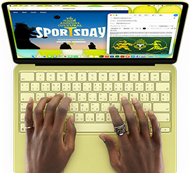 MacBook Neo, สีซิตรัส, มือวางบนคีย์บอร์ด, ผู้ใช้กำลังเขียนอีเมลเชิญเข้าร่วมกิจกรรมกีฬา, เว็บไซต์ของกิจกรรมเปิดอยู่ข้างๆ